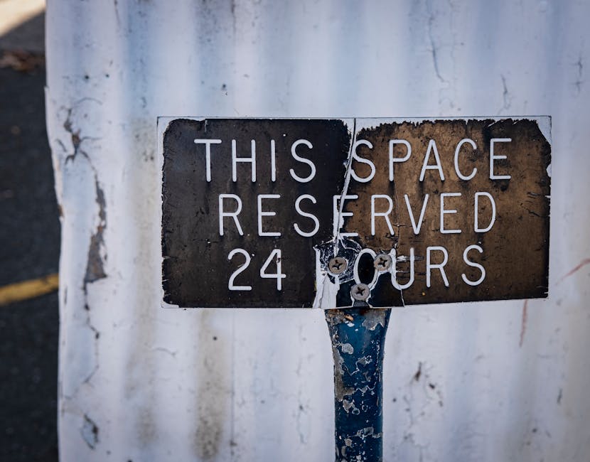 An outdoor scene showing a rectangular metal sign mounted on a rough stone wall, indicating 'PARKING WITH HOTEL PERMIT ONLY' in bold black letters. The sign is secured with four screws, one at each corner. The stone wall consists of large, irregularly shaped brownish stones with visible mortar joints. The sign is positioned at about eye level, suggesting it is meant for vehicles or pedestrians. This image is relevant to house removals and relocation services provided by Removal Company Haringey, particularly regarding parking regulations for home relocation or furniture transport in the Wood Green N22 area. The setting implies an urban environment where proper permits are essential for moving logistics, aligning with the process of planning a residential move, including vehicle access and parking permissions.
